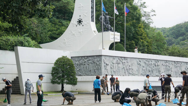 24일 오전 고양시 덕양구 관산동 소재 필리핀군 참전기념비에서 참가자들이 기념비 주변의 쓰레기를 줍고 잡초를 제거하고 있다. 신진욱기자