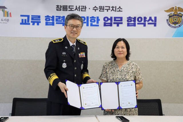 24일 김현우 수원구치소장(왼쪽)이 박미영 창룡도서관장과 업무협약식 후 기념사진을 촬영하고 있다. 수원구치소 제공