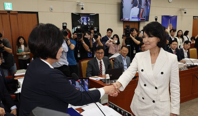 이진숙 방송통신위원장 후보자(오른쪽)가 지난 24일 서울 여의도 국회 과학기술정보방송통신위원회에서 열린 인사청문회에서 더불어민주당 소속 최민희 위원장에게 선서문을 전달한 후 악수하고 있다. 연합뉴스