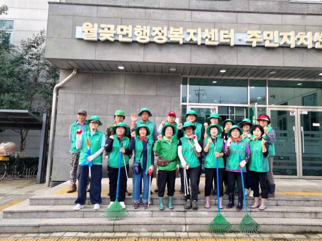 월곶면 남·여 새마을회 회원들이 환경정화에 앞서 기념촬영을 하고 있다. 월곶면 행정복지센터 제공