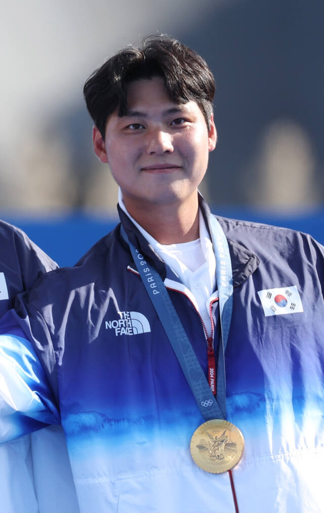 30일(한국시간) 프랑스 파리의 레쟁발리드에서 열린 남자 단체전 결승전에서 프랑스를 꺾고 남자 양궁 3연패를 기록한 이우석(27·코오롱엑스텐보이즈)이 금메달을 목에 걸고 기념촬영을 하고 있다. 연합뉴스