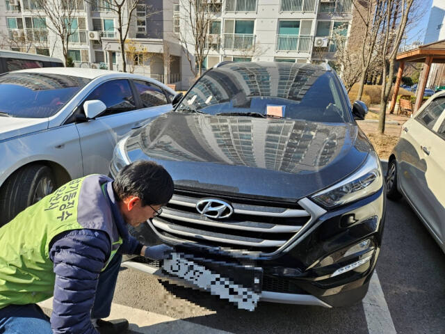오산시 채납기동단속반원이 지방세 체납 자동차의 번호판을 떼고 있다. 오산시 제공