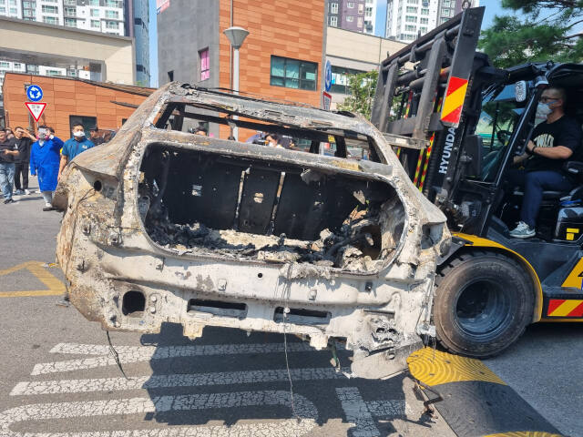 5일 오후 인천 서구 청라국제도시 한 아파트 지하주차장에서 불이 나 전소된 전기차가 지게차로 옮겨지고 있다. 정성식기자