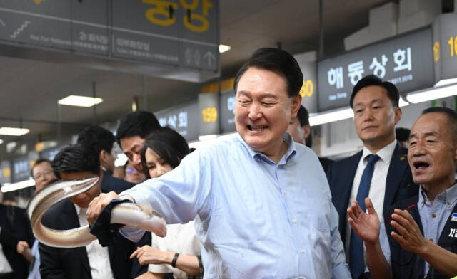 윤석열 대통령이 2023년 7월 27일 부산 중구 자갈치시장에서 장어를 직접 손으로 잡아 보고 있다. 연합뉴스