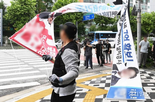 지난해 8월 인천 연수구 동춘동 소금밭사거리에서 연수구청 관계자들이 횡단보도 신호등에 걸려 있던 정당현수막을 강제 철거하고 있다. 경기일보DB