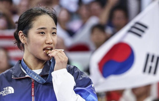 배드민턴 여자 단식서 28년 만에 금메달을 획득한 안세영의 작심 발언이 파장을 일으키고 있다. 5일 금메달 획득 후 시상식서 안세영이 금메달을 입에 물고 있다.연합뉴스