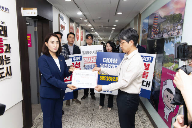 정영혜 민주당 원내대표가 홍보담당관 해임촉구안 김병수 시장 비서실 직원에게 전달하고 있다. 김포시의회 제공