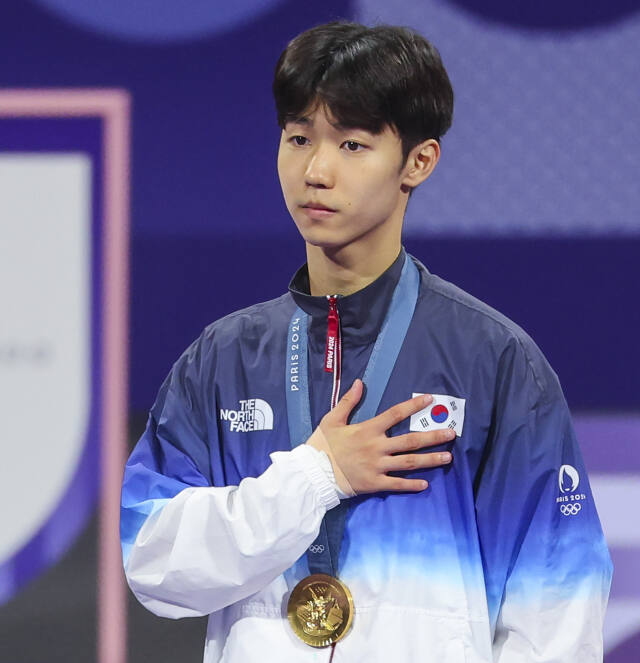 2024 파리 올림픽 태권도 남자 58㎏급서 금메달을 획득한 박태준이 시상식에서 금메달을 목에 걸고 국기에 대한 경례를 하고 있다.연합뉴스