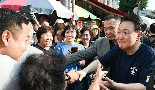 여름휴가 중인 윤석열 대통령이 지난 5일 경남 통영시 통영중앙시장을 찾아 상인, 시민들과 인사하고 있다. 대통령실 제공