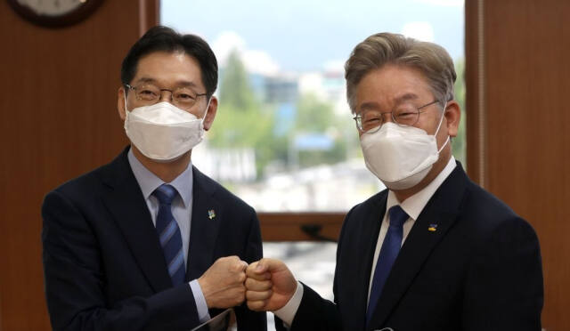 김경수 경남지사와 이재명 경기지사가 2021년 6월 17일 ‘경상남도·경기도·경남연구원·경기연구원 공동협력을 위한 정책 협약식’에 앞서 주먹 인사를 하고 있다. 연합뉴스