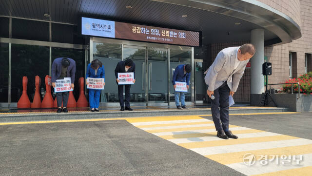 12일 평택시의회 민주당 소속 시의원들이 시의회 앞에서 시민에게 심려를 끼쳤드렸다며 머리를 숙이고 있다. 안노연기자