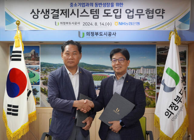 김용석 의정부도시공사 사장(왼쪽)이 상생결제시스템 도입을 위한 업무협약을 체결한 뒤 기념촬영하고 있다. 의정부도시공사 제공