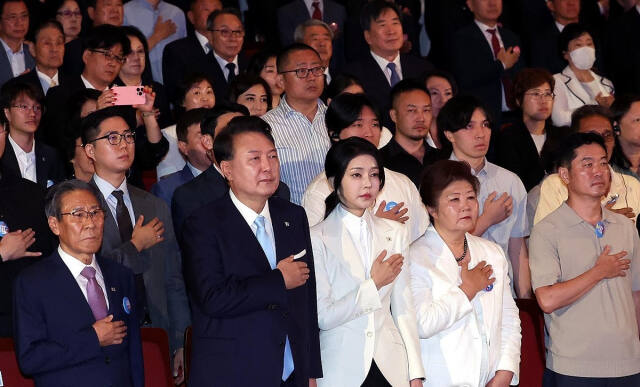 윤석열 대통령과 김건희 여사가 15일 서울 종로구 세종문화회관에서 열린 제79주년 광복절 경축식에서 이동일 순국선열유족회장 등 참석자들과 함께 국기에 대한 경례를 하고 있다. 대통령실 제공
