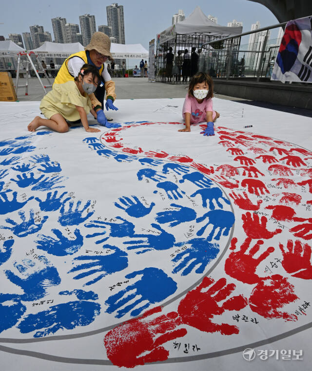 '제79주년 광복절 경축행사'가 열린 15일 인천 연수구 아트센터인천에서 태극기 핸드프린팅 행사에 참여한 시민들이 손바닥 도장으로 태극기를 채워나가고 있다. 조병석기자