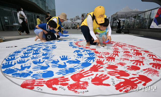 '제79주년 광복절 경축행사'가 열린 15일 인천 연수구 아트센터인천에서 태극기 핸드프린팅 행사에 참여한 시민들이 손바닥 도장으로 태극기를 채워나가고 있다. 조병석기자