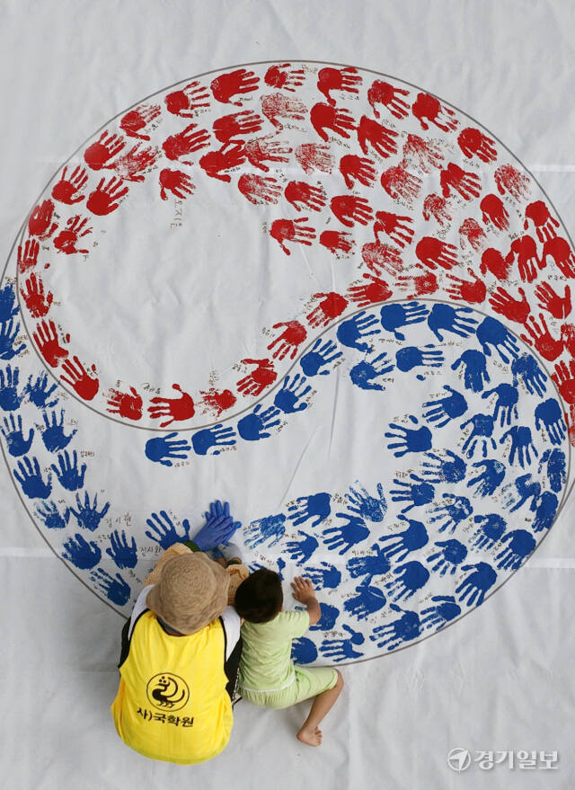 '제79주년 광복절 경축행사'가 열린 15일 인천 연수구 아트센터인천에서 태극기 핸드프린팅 행사에 참여한 시민들이 손바닥 도장으로 태극기를 채워나가고 있다. 조병석기자