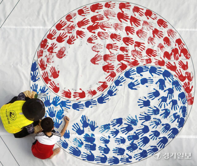 '제79주년 광복절 경축행사'가 열린 15일 인천 연수구 아트센터인천에서 태극기 핸드프린팅 행사에 참여한 시민들이 손바닥 도장으로 태극기를 채워나가고 있다. 조병석기자