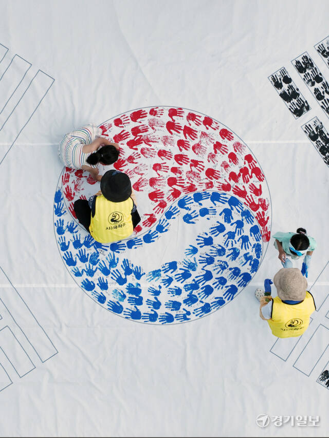 '제79주년 광복절 경축행사'가 열린 15일 인천 연수구 아트센터인천에서 태극기 핸드프린팅 행사에 참여한 시민들이 손바닥 도장으로 태극기를 채워나가고 있다. 조병석기자