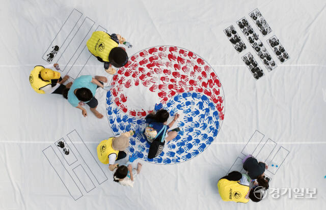 '제79주년 광복절 경축행사'가 열린 15일 인천 연수구 아트센터인천에서 태극기 핸드프린팅 행사에 참여한 시민들이 손바닥 도장으로 태극기를 채워나가고 있다. 조병석기자