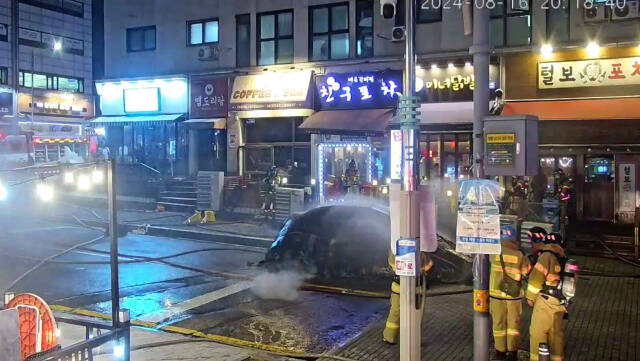 16일 오후 용인시 기흥구 구갈동의 한 도로에 세워져 있던 테슬라 전기차량에서 불이 나 소방당국이 화재를 진압하고 있다. 경기도소방재난본부 제공