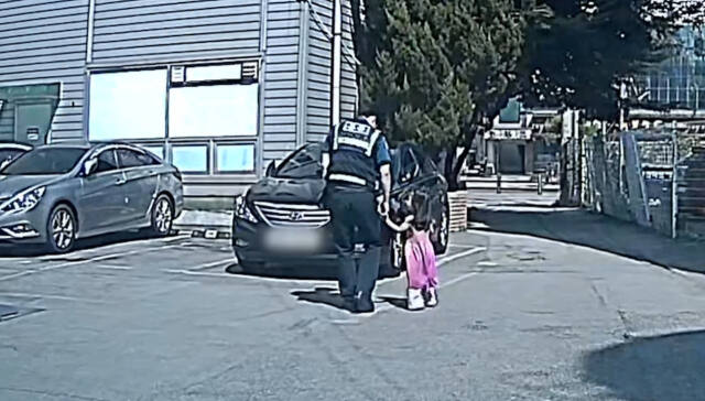 지난달 14일 길을 잃은 4세 여아가 주민과 경찰의 도움으로 가족의 품으로 돌아왔다. 사진은 당시 경찰관이 길을 잃은 여아와 함께 걸으며 집을 찾는 모습. 평택경찰서 제공