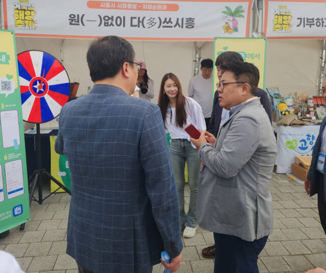 김동구 한강유역환경청장(오른쪽)과 시흥시 관계자들이 지난 23일부터 시흥 웨이브파크에서 열린 제3회 시흥 거북섬 해양축제장에서 다회용기 홍보 부스를 점검하고 있다. 한강청 제공