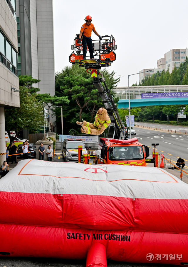 최근 부천시 호텔 화재 당시 투숙객 2명이 에어매트로 뛰어내리다 사망한 가운데 26일 오후 수원남부119안전센터에서 소방대원들이 화재현장 대응력 강화를 위한 에어매트(공기안전매트) 전개 훈련을 하고 있다. 윤원규기자