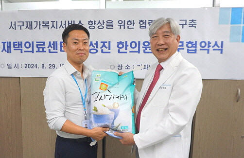 29일 인천 서구 가좌노인문화센터에서 김성진 원장과 권승원 센터장이 복지 사각지대 어르신을 위한 쌀을 들고 기념 촬영을 하고 있다.김샛별기자