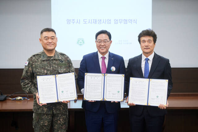지난 5월 강수현 양주시장(가운데), 양형규 남면주민협의체 위원장(오른쪽), 25사단장이 도시재생사업 업무협약을 체결하고 기념사진을 찍고 있다. 양주시 제공