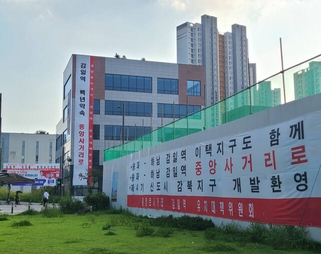 하남시 감일역 중앙로 사거리에 송파하남선 101정거장 입지 변경을 요구하는 문구가 적힌 대형 현수막이 걸려있다, 송파하남선 중앙로 사거리 감일역 유치위원회 제공