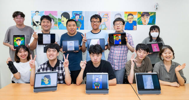 수원특례시 고향사랑기금 활용 사업으로 진행 중인 호매실장애인종합복지관 디지털 드로잉 작가 양성 교육 참여자 등 관계자들이 작품이 담긴 태블릿을 들고 기념촬영을 하고 있다. 수원특례시 제공