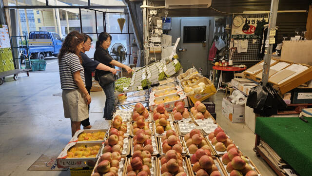 4일 인천 남동구 남촌농산물도매시장이 한산한 가운데, 한 과일가게에서 시민들이 과일을 살펴보고 있다. 장민재 기자