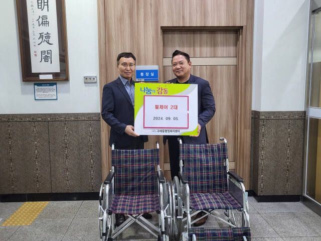 김경수 구래동장(왼쪽)과 이경규 민간위원장이 기증된 휠체어 앞에서 기념촬영을 하고 있다. 김포시 구래동 제공
