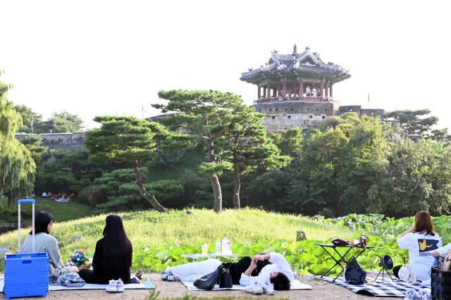 시민들이 수원화성 방화수류정이 보이는 용연에서 가을 피크닉을 즐기고 있다. 수원특례시 제공
