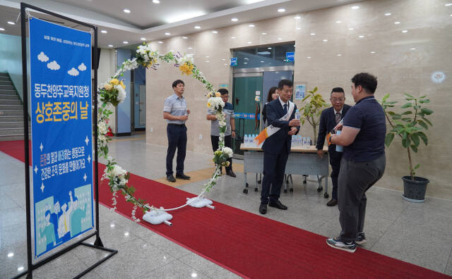 임정모 교육장이 12일 청사 입구에서 출근길 직원들과 인사하며 청렴수를 나눠주고 있다. 동두천양주교육지원청 제공