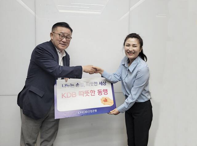 KDB산업은행 김은경 홍보팀장이 한국어린이난치병협회 윤완채 운영위원장(왼쪽)에게 어린이 환아 치료 후원금 3천만원을 전달하고 있다. 한국어린이난치병협회 제공