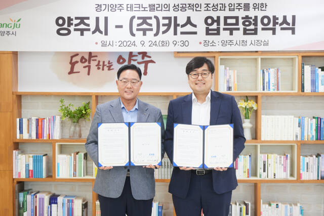 강수현 양주시장(왼쪽)과 ㈜카스 김태인 대표가 24일 양주시장실에서 양주테크노밸리 입주를 위한 업무협약을 체결한 뒤 협약서를 들어 보이고 있다. 양주시 제공