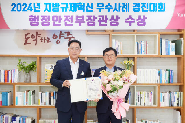 강수현 양주시장(왼쪽)이 24일 시장실에서 지방규제혁신 우수사례 경진대회에서 행정안전부장관상을 수상한 이송주 기획예산과장에게 상을 전수하고 축하했다. 양주시 제공