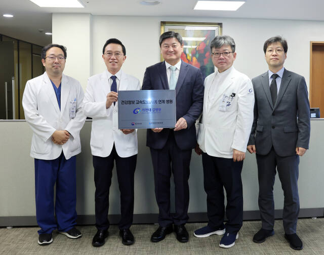 25일 가천대 길병원을 방문한 염민섭 한국보건의료정보원장(가운데)이 김우경 병원장(가운데 왼쪽)에게 건강정보 고속도로 사업 현판을 전달하고 있다. 가천대 길병원 제공