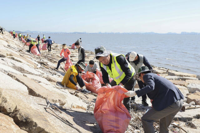 지난 24일 영종국제도시 남측해안방조제 일대에서 폐기물을 수거하고 있다. 중구청 제공