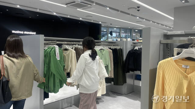 지난달 갤러리아 광교점에 문을 연 무신사스탠다드를 찾은 고객이 녹색 셔츠를 살펴보고 있다. 금유진기자