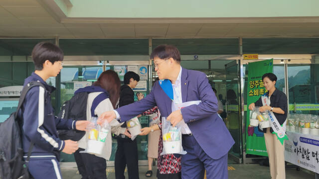 오정수 농협 양주시지부장(오른쪽)이 26일 회천중학교에서 등교하는 학생들에게 컵밥, 식혜, 우유를 나눠주고 있다. 농협 양주시지부 제공