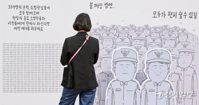 ‘제1회 국민과 함께 119 메모리얼데이’가 열린 5일 평택시 포승읍 소방관 이병곤길 일원에서 한 시민이 순직소방관들의 이름을 살펴보고 있다.