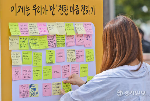 5일 평택시 포승읍 소방관 이병곤길 일원에서 열린 제1회 국민과 함께 119 메모리얼데이에서 한 시민이 순직소방관에게 메세지를 붙이고 있다.
