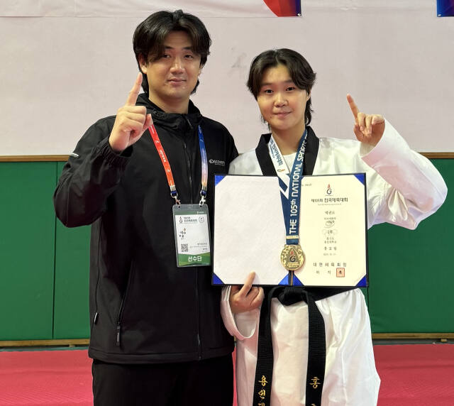 제105회 전국체전 사전경기인 태권도 여대부 67㎏급서 금메달을 획득한 홍효림(오른쪽)이 조유진 코치와 시상식 후 기념촬영을 하고 있다.용인대 제공