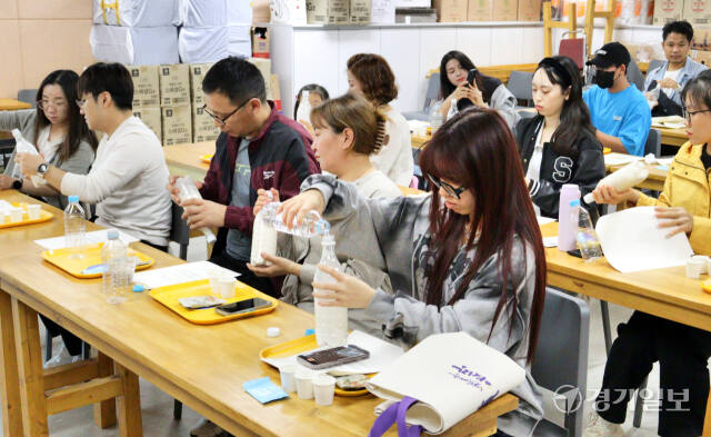 지난 12일 오후 용인시 처인구 용인중앙시장 회의실에서 열린 다문화 막걸리 체험 클래스에서 참가자들이 막걸리를 직접 만드는 체험을 하고 있다. 송상호기자