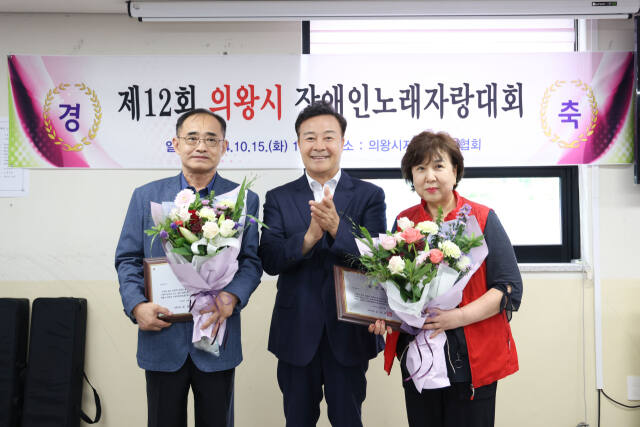 제12회 의왕시 장애인 노래자랑대회에서 장애인 유공자 표창자가 김성제 의왕시장(가운데)과 기념사진을 찍고 있다. 의왕시 제공