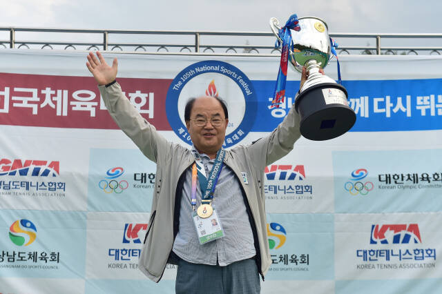 제105회 전국체전 테니스서 3연패를 달성한 경기도의 정용택 총감독이 우승트로피를 들고 활짝 웃고 있다.경기도테니스협회 제공