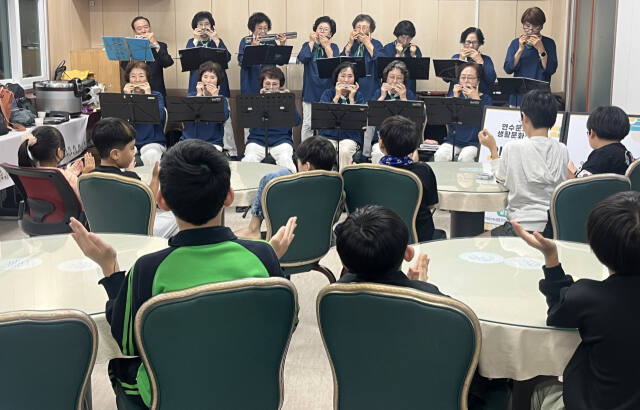 17일 인천 연수구 가온누리지역아동센터 아이들이 실버하모니카 오케스트라의 공연을 감상하면서 박수를 치고 있다. 김샛별기자