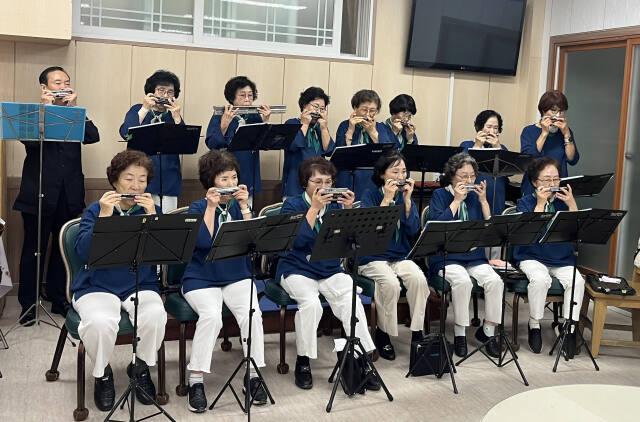 17일 인천 연수구 가온누리지역아동센터에서 실버하모니카 오케스트라가 동요 ‘반달’을 연주하고 있다. 김샛별기자
